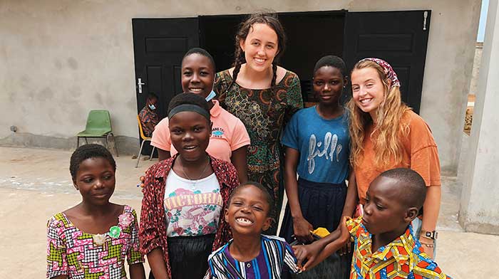 Interns smiling with kids in village